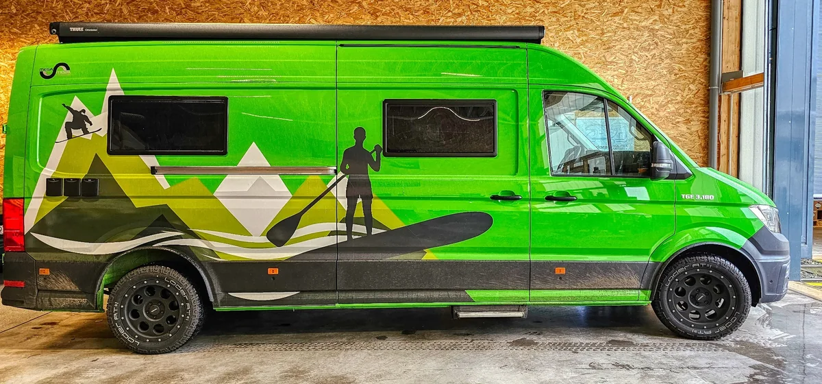 Grüner MAN TGE Mega Mobil Camper in der CANFORCE Werkstatt
